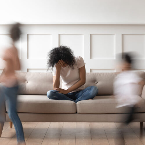 Frustrated stressed african mom feel tired annoyed about noisy kids Frustrated stressed single african mom having headache feel tired annoyed about noisy active kids playing at home, upset disturbed black mother fatigued of difficult disobedient misbehaving children
